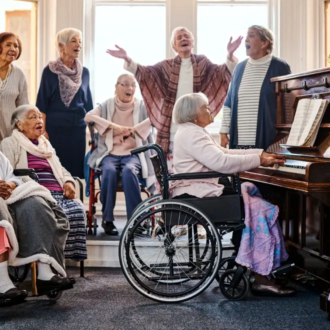 Group of senior residents singing around the piano